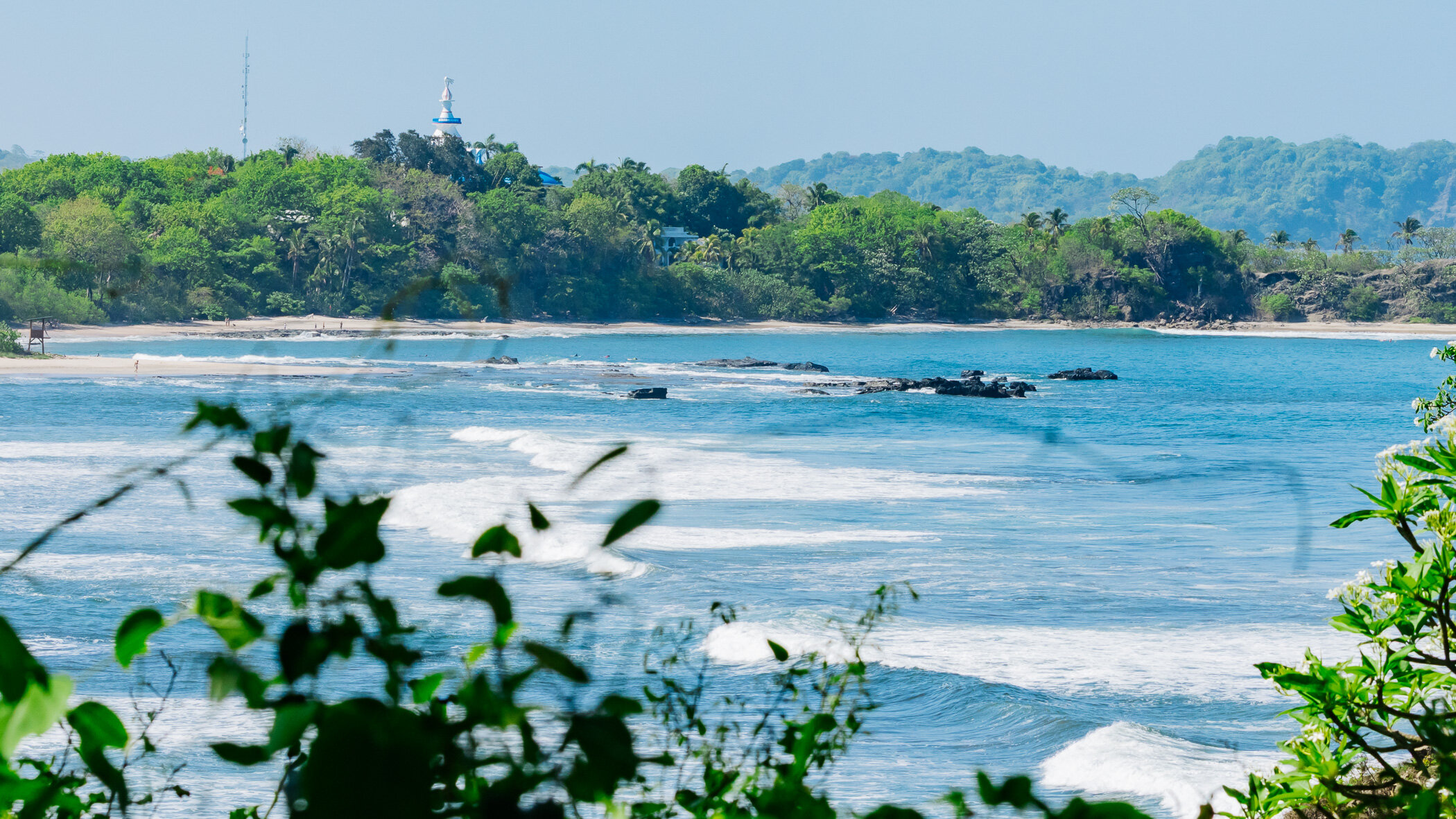 Playa Pelada, Nosara: olas llegando a la playa con la vegetación verde detrás